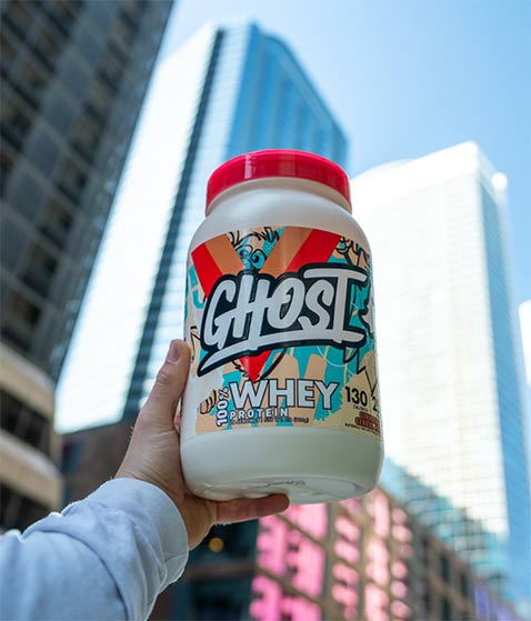 A man holding ghost whey protein